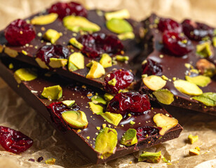 Dark chocolate bark with pistachios and cranberries, rustic macro detail
