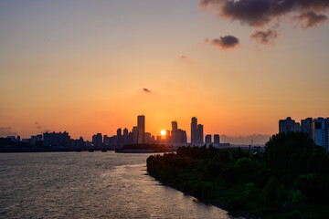 Fototapeta premium The night view of the city of Yeouido, a high-rise building, shot at Dongjak Bridge in Seoul at sunset