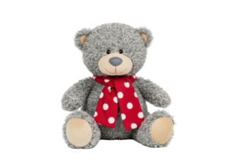 Isolated gray teddy bear with a red and white polka dot scarf sitting upright indoors