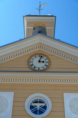 Historic yellow building with clock tower and weather vane