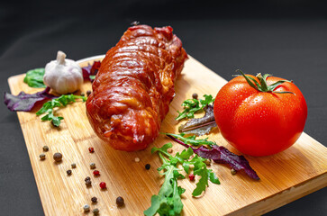 Hot pork with tomatoes, onions, garlic, mixed lettuce. Served on wooden board, on black tablecloth.