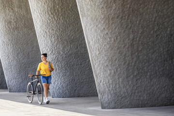 Woman walking with her bicycle in a modern city environment