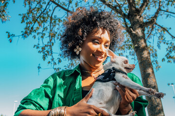 afro woman with her pet in the park outdoors