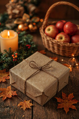 Warm and cozy holiday scene with a gift, candle, and fresh apples on a wooden table