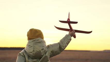 little girl playing with toy plane at sunset sky, happy family, childhood dream of flying, cheerful child running around field, kid wants to become pilot, fantastic travel baby vacation, enjoy nature.