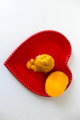 Iced mango cream in red saucepan with a white background and copy space.