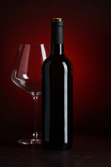 Wine Bottle and Empty Glass on Red and Black Gradient Background