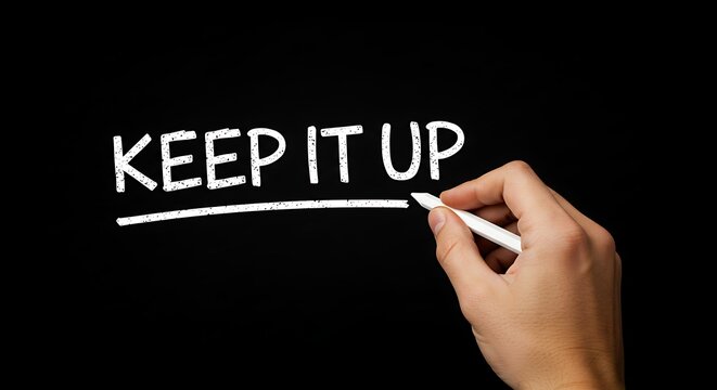 Hand writing keep it up message on black background with chalk