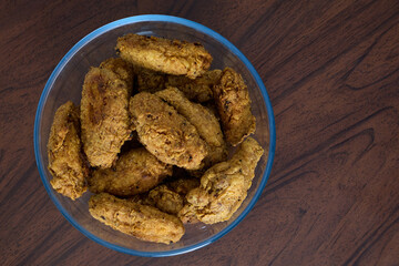 Fried chicken wings in a glass bowl.