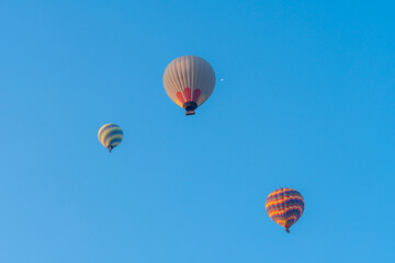 Three hot air balloons against a blue sky. Beautiful view of colourful hot air balloons from below. Cappadocia