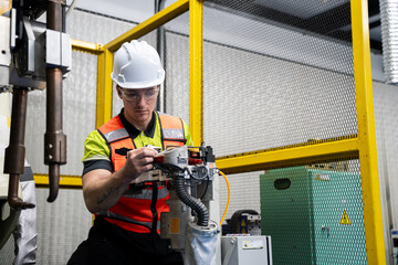 Engineer working with an industrial robot for training and safety. Hands-on robotics, automation, AI learning, STEM education, and digital skills for the future workforce © winnievinzence