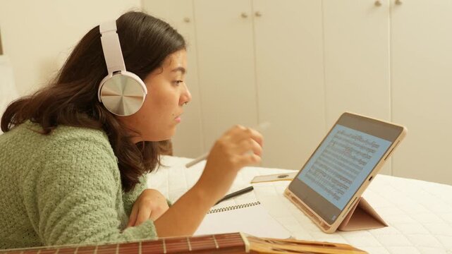 Young female songwriter composing music at home