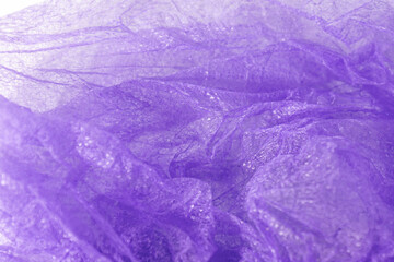 A macro shot of a purple disposable hairnet showing its fine mesh texture and layers, with soft...