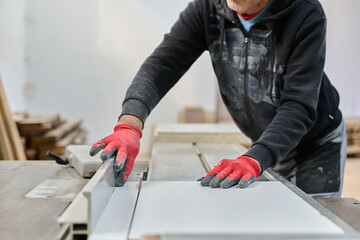 Close Up of Worker Carefully Cutting and Planing Wooden Pieces for Furniture in Wood Industry