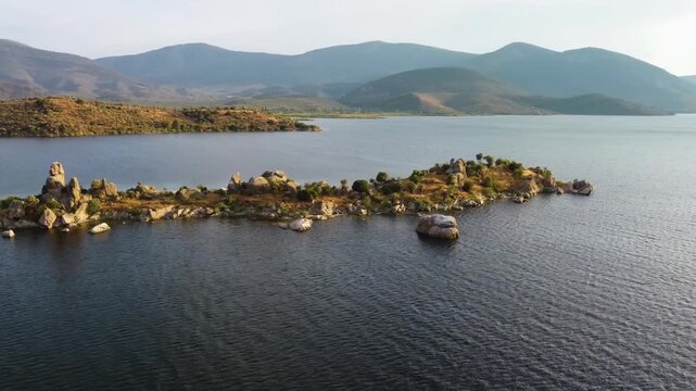 aerial footage showcasing the tranquil beauty of Lake Bafa in Turkey, featuring its pristine waters, lush surrounding landscapes, and the historical ruins and islands scattered across the lake. This f