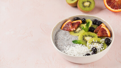 Healthy breakfast bowl with chia pudding, kiwi, blood orange, and berries. Copy space