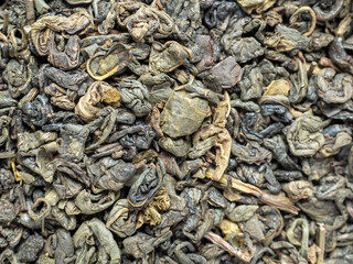 close-up of curled green tea leaves. food background. Tea drinking tradition of China and India. Macro photo, top view, flat lay