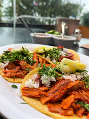 Tacos al pastor served with pineapple, cilantro and onion at a taquería in México