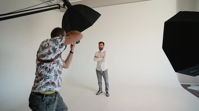 Professional photographer taking pictures of a model in a photo studio