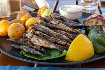 A plate of food with fish, potatoes, and lemon slices