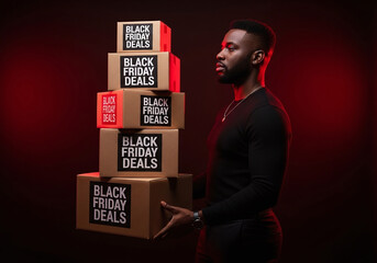 Stylish man carrying Black Friday deals boxes with a determined look, ready for shopping season and holiday promotions during the retail rush