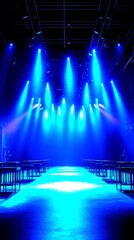 Bright blue stage lights illuminate an empty runway in a modern performance venue - High Contrast