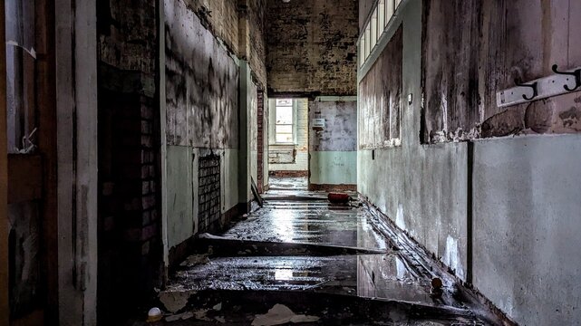 Creepy dark empty hallway interior. Eerie atmosphere corridor light at the end. Peeling paint, warped wet reflective floor. Derelict abandoned deserted hall flooding damage. Natural disaster aftermath
