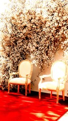 Elegant chairs in front of a blooming floral backdrop on a red carpet at a celebration venue - High Contrast