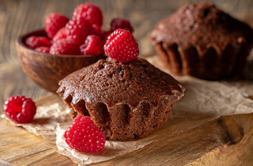 Freshly baked chocolate muffins artfully adorned with luscious ripe raspberries