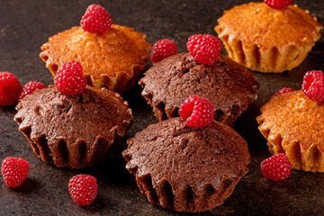 Delicious muffins and ripe raspberries displayed on a stylish black kitchen table