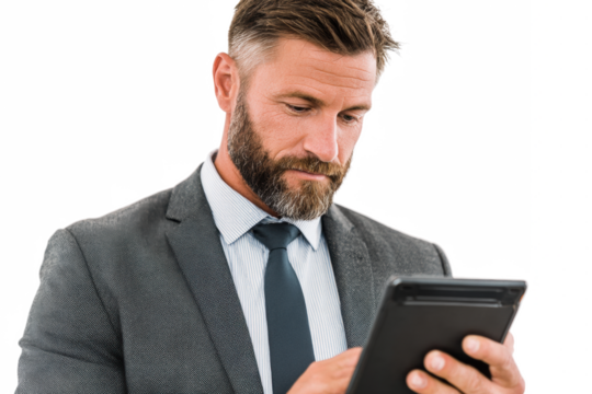 A focused businessman in a suit and tie intently looking at a tablet device.
