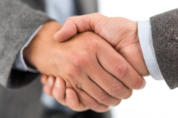 Close-up shot of two hands clasped in a firm handshake, symbolizing agreement.