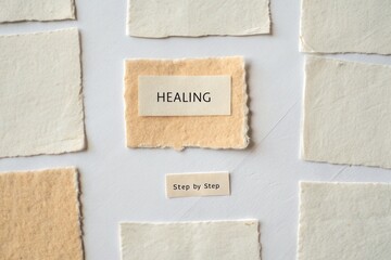 Text reading Healing on beige paper step by step arrangement