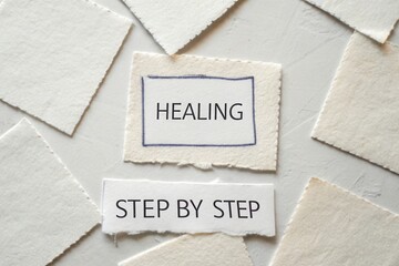 Torn papers arranged with healing and step by step text