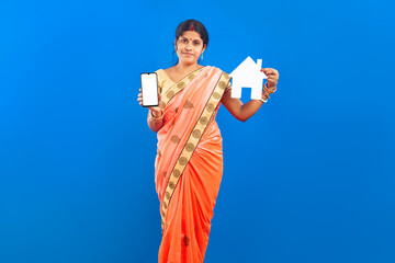 Traditional Indian female with blank mobile phone and paper home icon