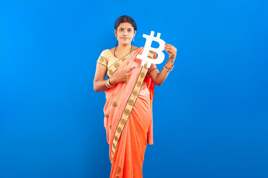 Indian Woman in Saree Pointing finger at Bitcoin Symbol on Blue Background - Powered by Adobe