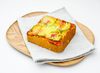 baked pizza toast, topped with melted mozzarella cheese, tomato sauce, and fresh basil, served on a wooden plate on white background side view of quick lunch, and breakfast
