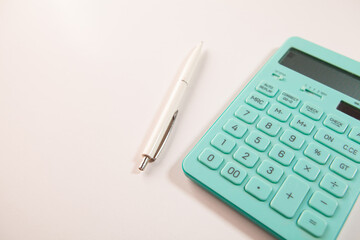 Calculator and pen on the white background, business concept.