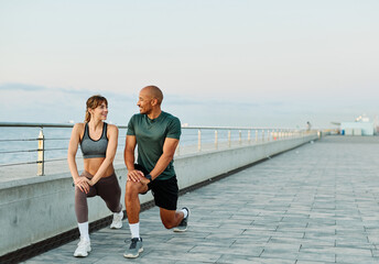 Portrait os a happy beautiful couple exercising and stretching outdoors