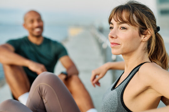 Smiling active young couple jogging exercising and having fun and laughing together taking a break after walking and running in the park, fitness and healhty living concept