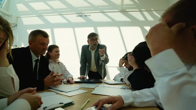 Angry senior boss scolding his employees during meeting
