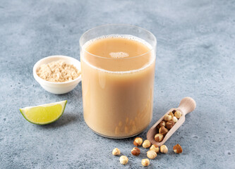 Sattu sharbat is an Indian drink made from roasted black chickpea flour, sugar and water on a blue background