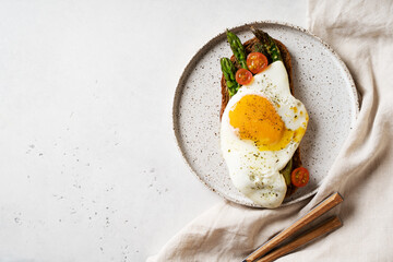 Toast with fried egg, asparagus and tomatoes