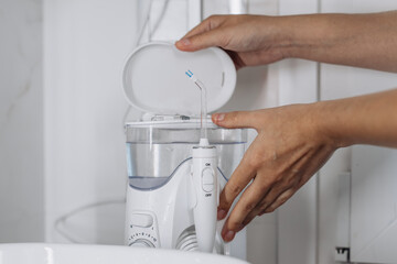 A home water flosser for teeth and oral care, placed in a bathroom interior. Concept: a modern and efficient solution for daily oral hygiene.