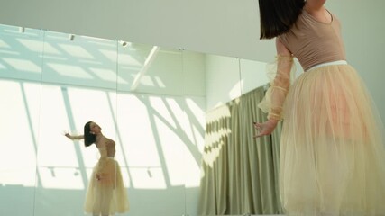 Graceful ballerina performing a lyrical dance in a sunlit studio