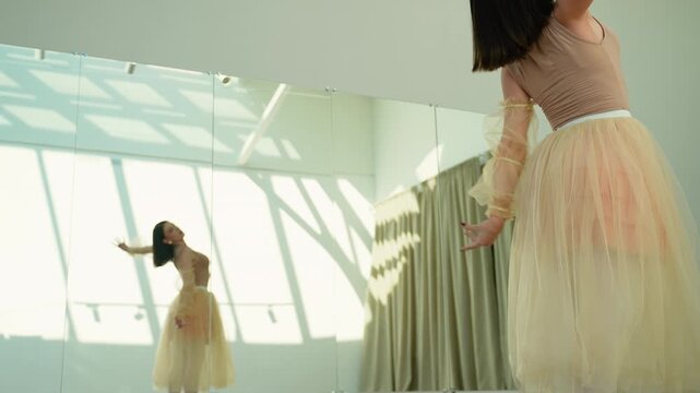 Graceful ballerina performing a lyrical dance in a sunlit studio