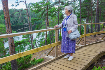 An elderly woman who came on a tourist excursion stands on the observation deck of the island of Valaam. Russia