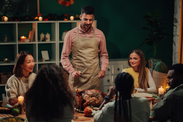 Man carving thanksgiving turkey for friends and family gathering