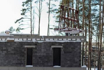A crane lifts plastic windows at a construction site