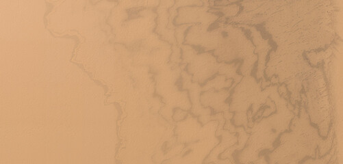 Aerial view of a desert landscape with sand dunes and patterns created by wind and erosion, showcasing the arid beauty and natural textures of the terrain